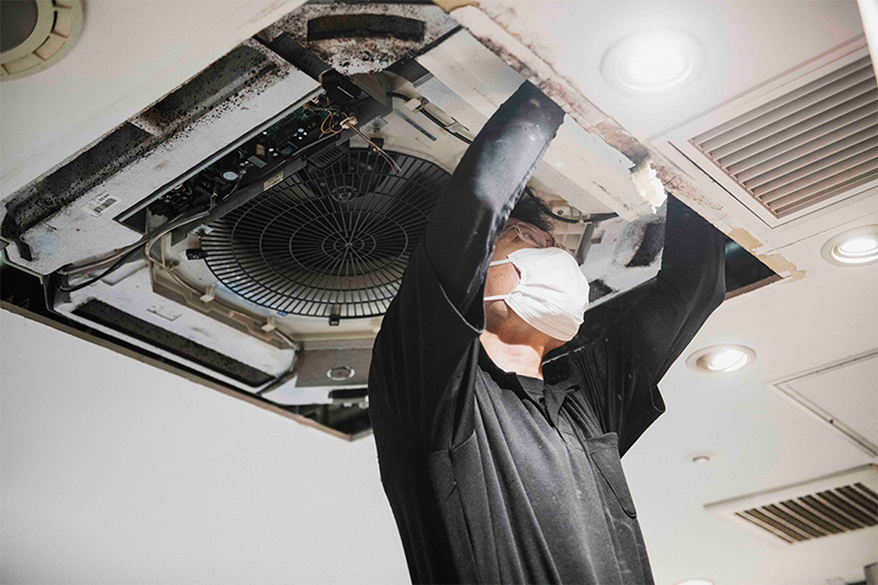 熟練技師が業務用エアコン施工する写真
